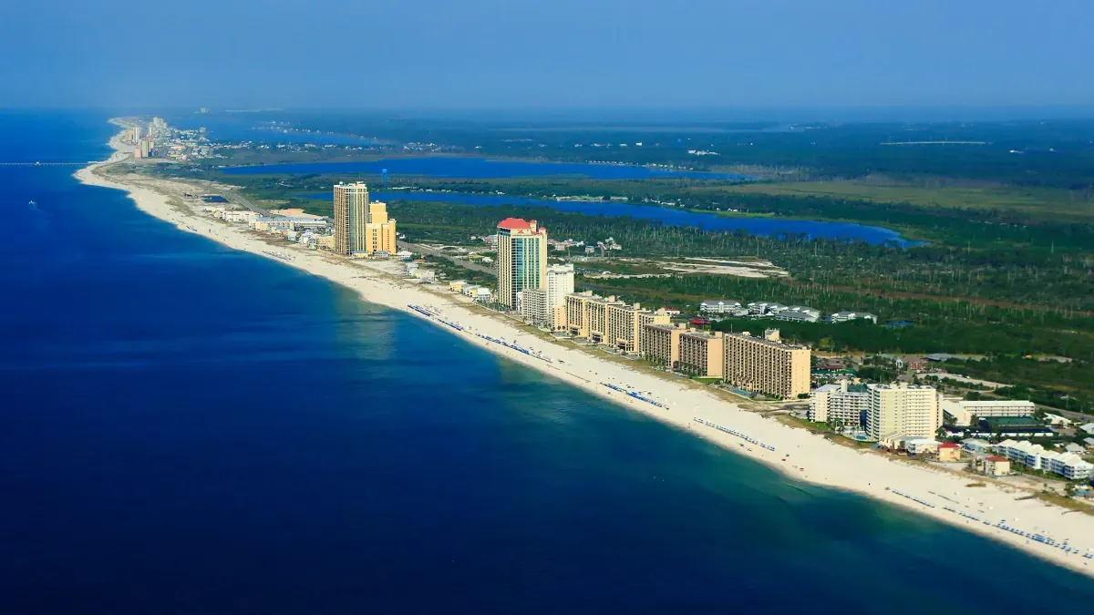 Aerial view of Gulf Shores, and Orange Beach Alabama, with white-sand beaches, turquoise water, and beachfront condos.